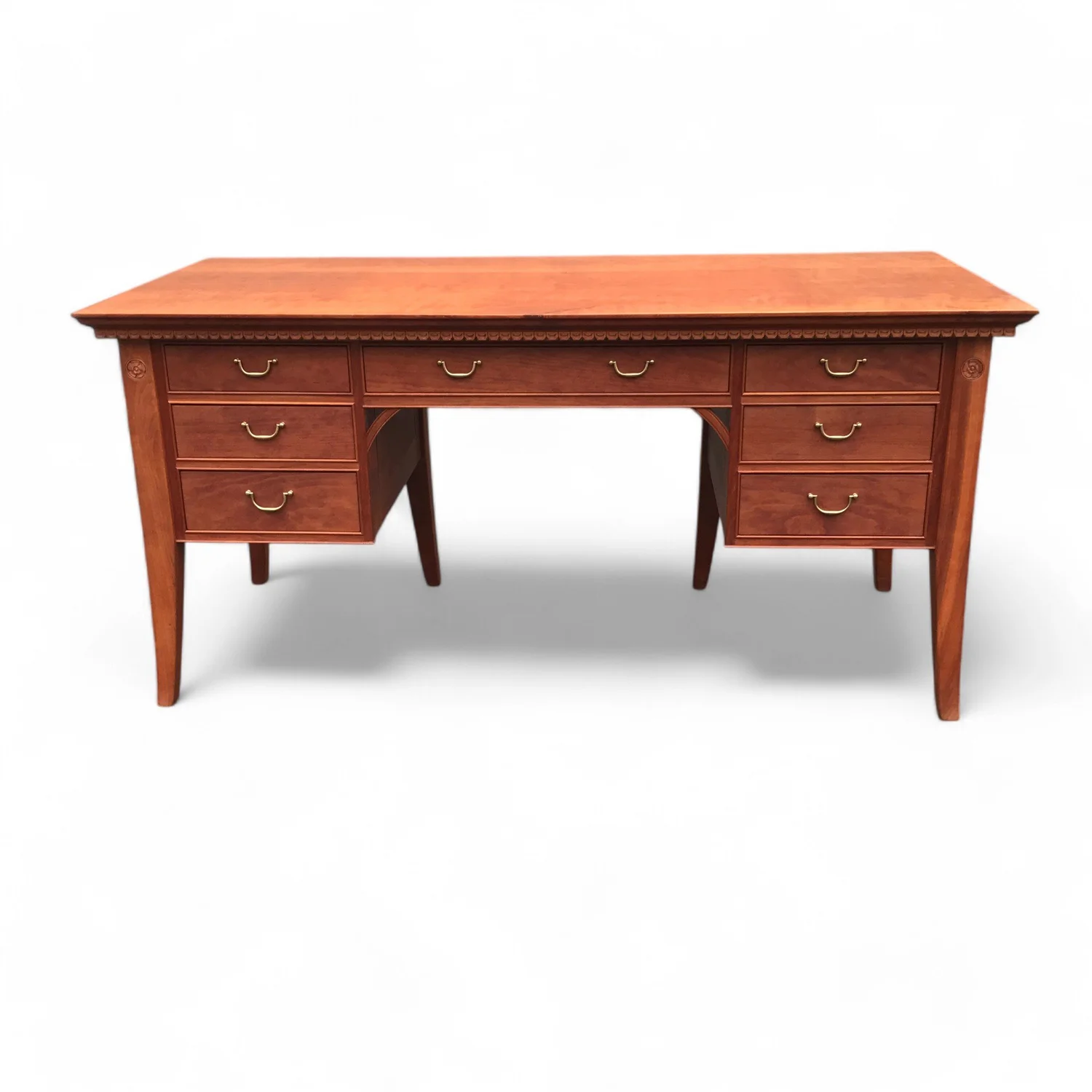Warm wood writing desk with nine drawers and brass pulls